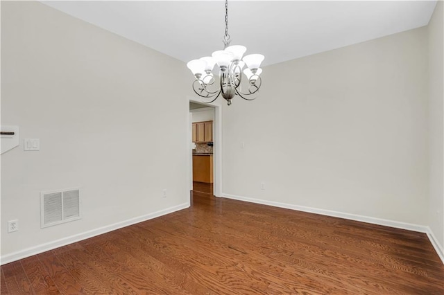 3485 Walnut Rdg, Atlanta, GA 30349 - spare room with a chandelier, baseboards, and dark wood-type flooring