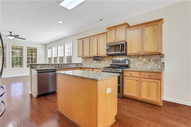3485 Walnut Rdg, Atlanta, GA 30349 - kitchen with stainless steel appliances, a center island, dark wood-style floors, a peninsula, and a ceiling fan