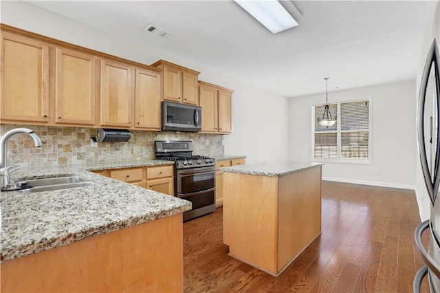 3485 Walnut Rdg, Atlanta, GA 30349 - kitchen with stainless steel appliances, a sink, decorative backsplash, a center island, and light stone countertops