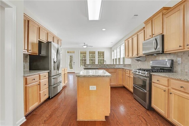 3485 Walnut Rdg, Atlanta, GA 30349 - kitchen with stainless steel appliances, light brown cabinets, a sink, dark wood-style floors, and backsplash