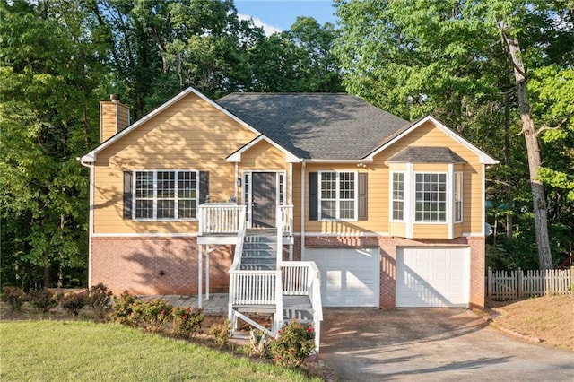view of front of home featuring aphalt driveway, fence, a chimney, brick siding, and an attached garage