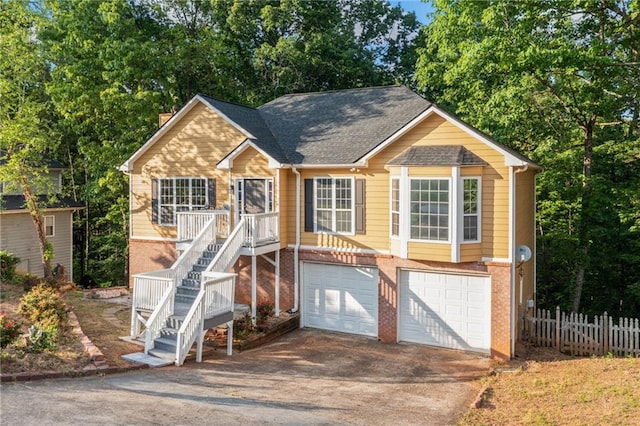 view of front of home with an attached garage, fence, stairway, and concrete driveway