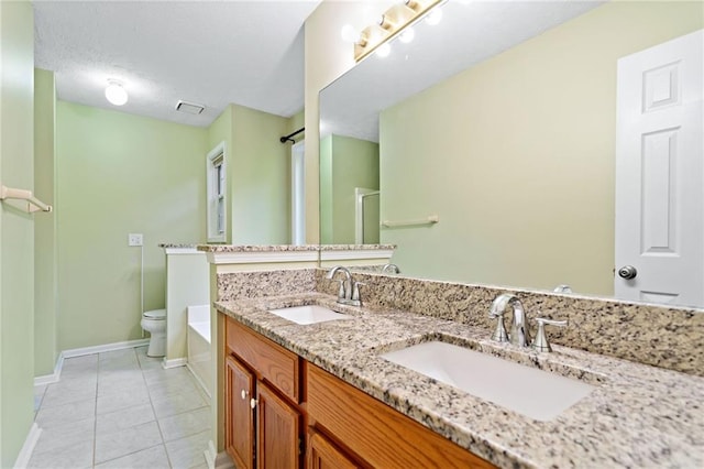 bathroom with a sink, baseboards, tile patterned flooring, and toilet