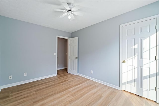 unfurnished bedroom with a ceiling fan, baseboards, and light wood-style flooring