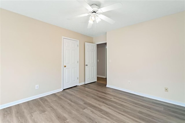 unfurnished bedroom featuring light wood-type flooring, baseboards, and ceiling fan