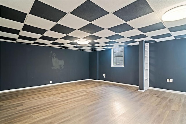 spare room with baseboards and wood finished floors