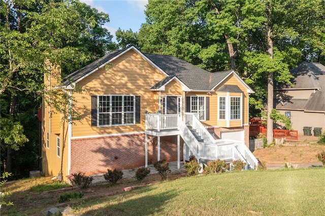 back of property with a chimney, a yard, stairway, and brick siding