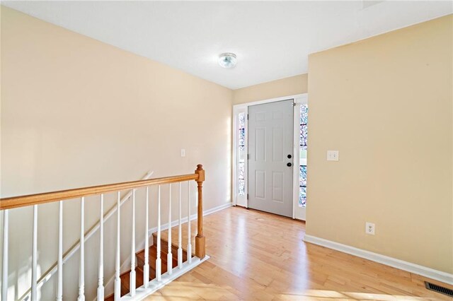 foyer with visible vents, light wood-style flooring, and baseboards