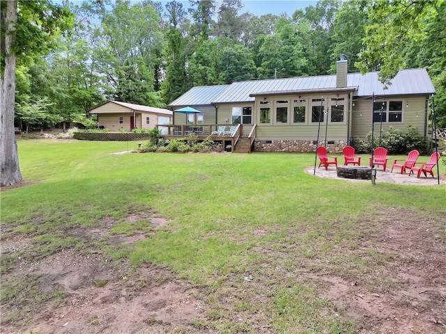 184 Bradley Rd, Jackson, GA 30233 - back of house with a fire pit, a wooden deck, a chimney, metal roof, and a lawn