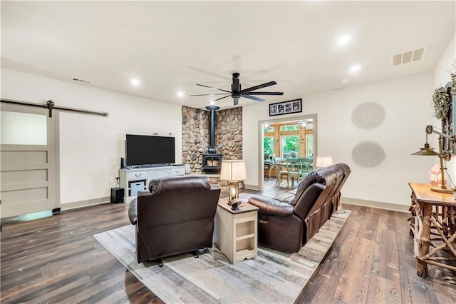 184 Bradley Rd, Jackson, GA 30233 - living area featuring a wood stove, a barn door, ceiling fan, baseboards, and wood finished floors