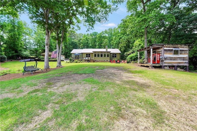 184 Bradley Rd, Jackson, GA 30233 - view of grassy yard featuring exterior structure, an outdoor structure, and view of wooded area