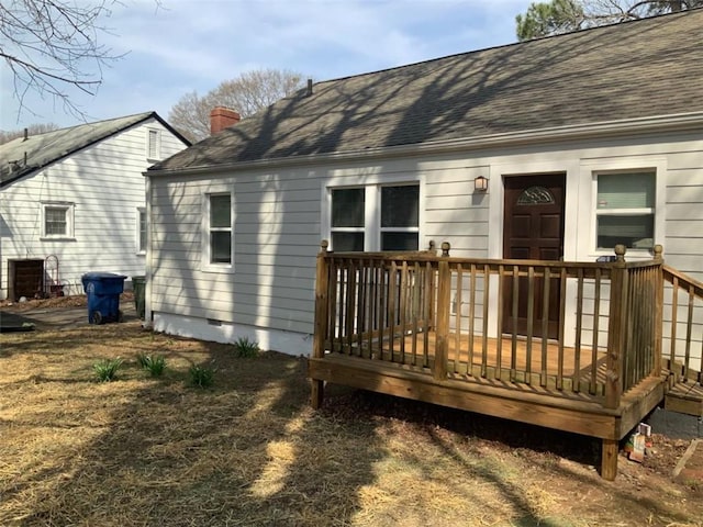 back of house featuring crawl space, a deck, a chimney, and roof with shingles