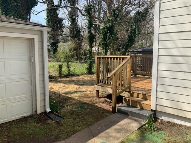 view of yard with a garage, a deck, and fence