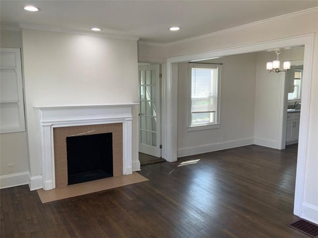 unfurnished living room featuring wood finished floors, baseboards, a fireplace, crown molding, and a chandelier