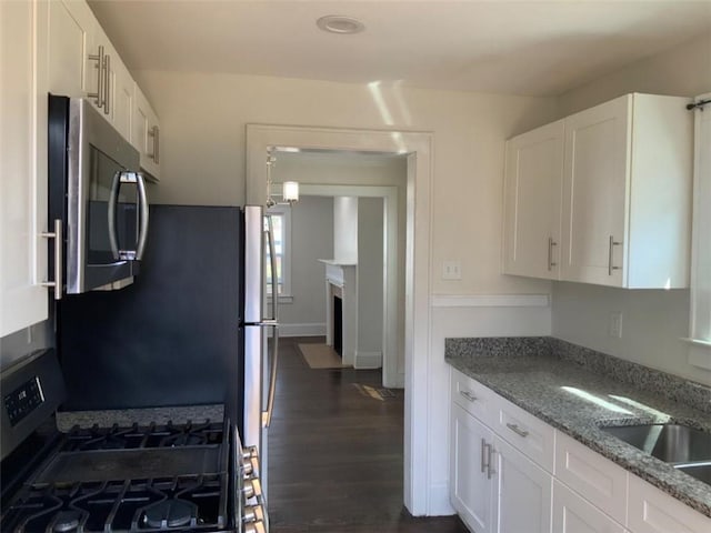 kitchen featuring stone counters, white cabinets, dark wood finished floors, and appliances with stainless steel finishes