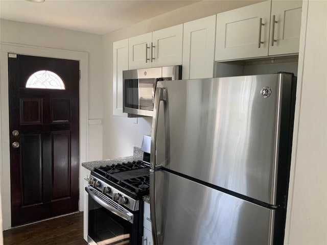 kitchen featuring appliances with stainless steel finishes, dark wood-style floors, and white cabinetry