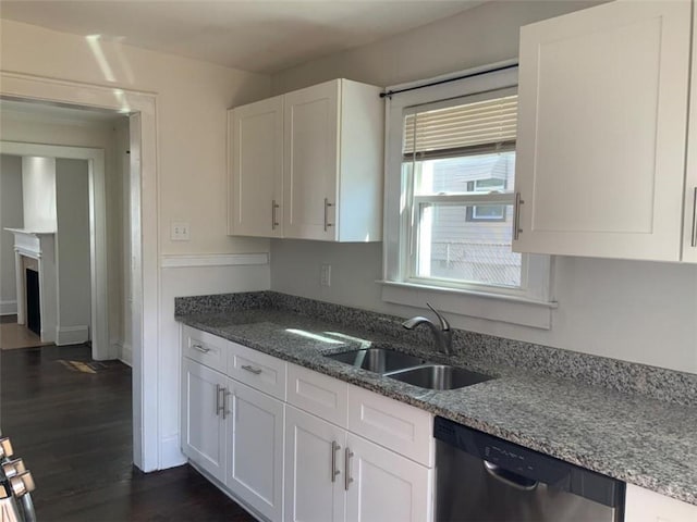 kitchen with a sink, dark wood-style floors, white cabinetry, stone counters, and dishwasher