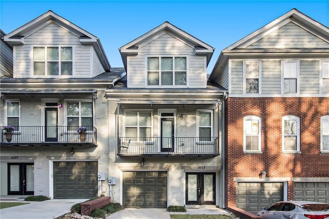6023 Brookside Oak Cir, Norcross, GA 30093 - townhome / multi-family property with an attached garage, brick siding, french doors, driveway, and a balcony