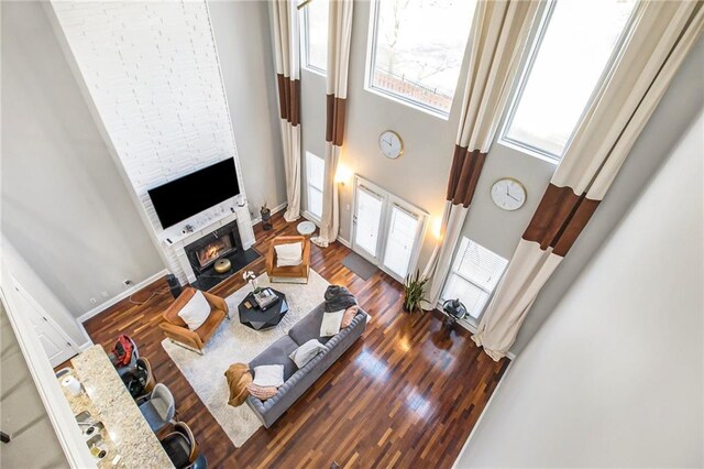 6023 Brookside Oak Cir, Norcross, GA 30093 - living room featuring a towering ceiling, a warm lit fireplace, and wood finished floors