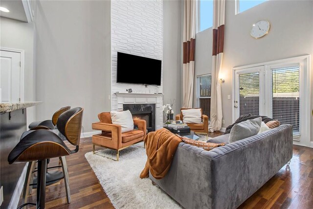 6023 Brookside Oak Cir, Norcross, GA 30093 - living room featuring a towering ceiling, a warm lit fireplace, dark wood-style floors, and baseboards