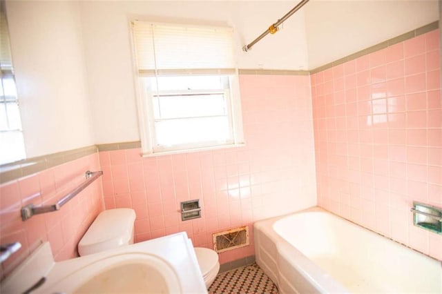 full bathroom featuring tile walls, toilet, shower / washtub combination, and sink