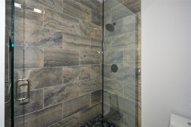 bathroom with toilet and a shower with shower door