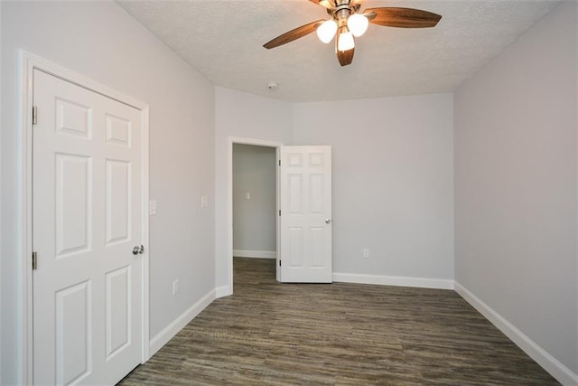 unfurnished bedroom with dark hardwood / wood-style flooring, a textured ceiling, and ceiling fan