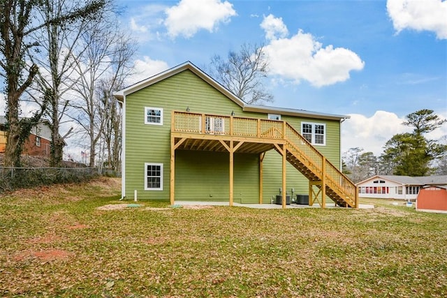 back of property with a wooden deck, central AC, and a lawn