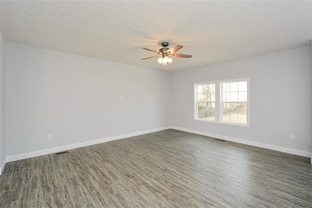 empty room with ceiling fan and dark hardwood / wood-style flooring