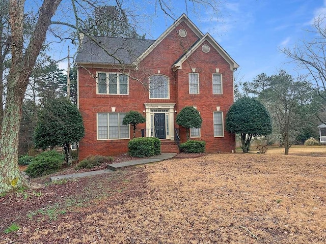 colonial inspired home featuring brick siding