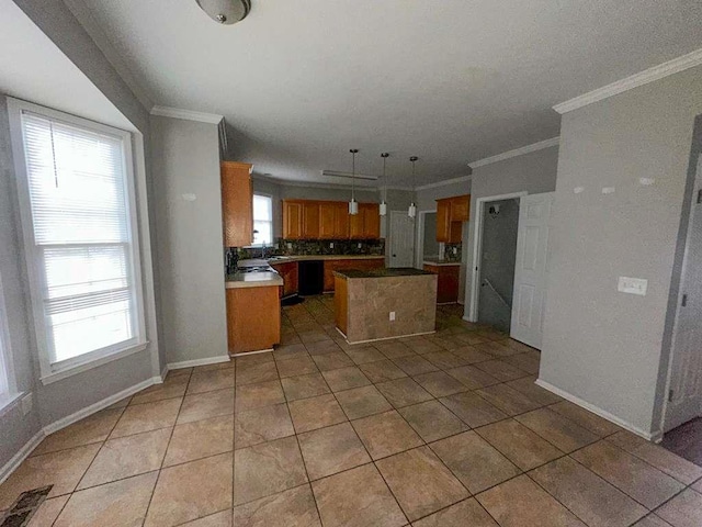 kitchen featuring brown cabinetry, backsplash, a center island, light tile patterned flooring, and crown molding