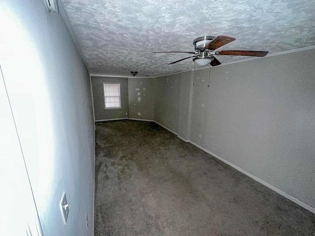 unfurnished room featuring baseboards, ceiling fan, a textured ceiling, and carpet