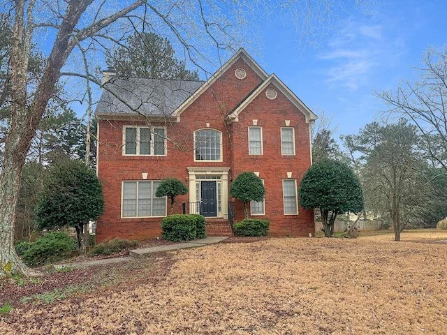 colonial-style house featuring brick siding