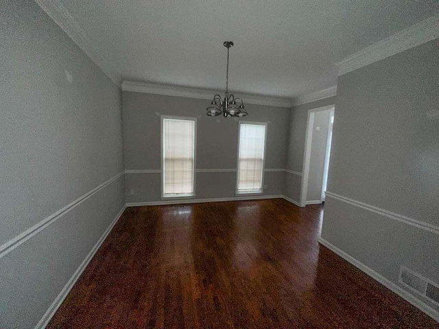 unfurnished dining area with an inviting chandelier, wood finished floors, crown molding, and baseboards