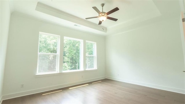 7020 Cottage Grove Dr, Flowery Branch, GA 30542 - empty room featuring a tray ceiling, wood finished floors, and a ceiling fan