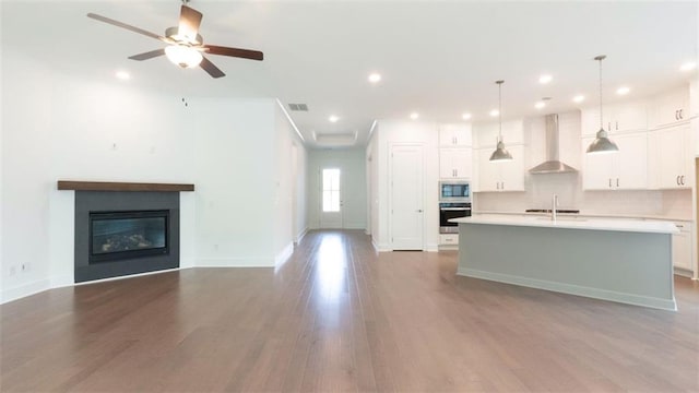 7020 Cottage Grove Dr, Flowery Branch, GA 30542 - kitchen with appliances with stainless steel finishes, wall chimney exhaust hood, a center island with sink, open floor plan, and recessed lighting