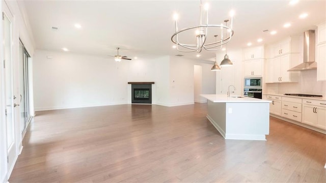 7020 Cottage Grove Dr, Flowery Branch, GA 30542 - kitchen featuring wall chimney range hood, oven, cooktop, stainless steel microwave, and ceiling fan