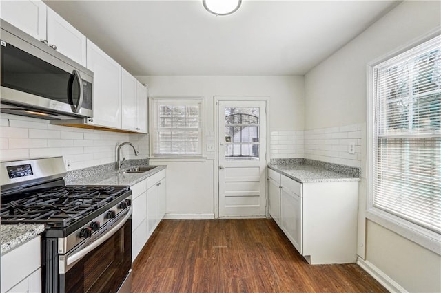 kitchen with white cabinetry, stainless steel appliances, dark wood-type flooring, and sink