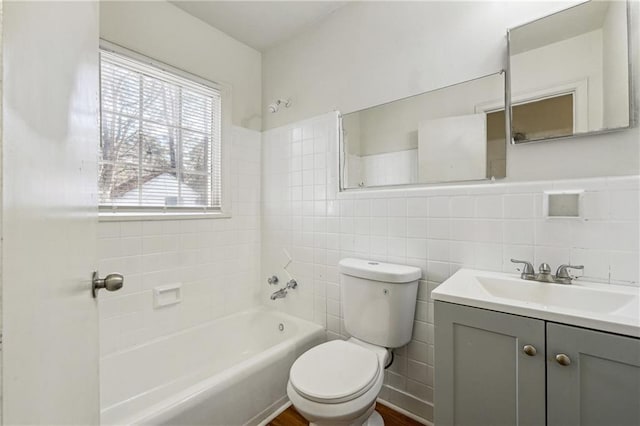 full bathroom with vanity, tile walls, toilet, and washtub / shower combination