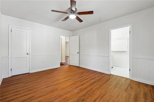 unfurnished bedroom with wood-type flooring, connected bathroom, and ceiling fan