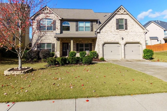 view of front facade with brick siding, a front yard, fence, a garage, and driveway