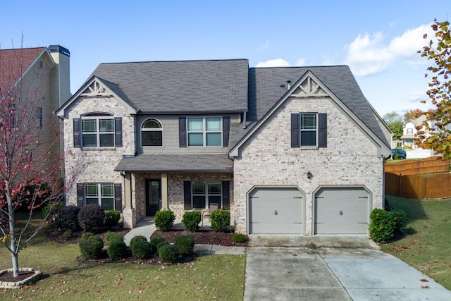 view of front of house with a garage, brick siding, fence, concrete driveway, and a front lawn