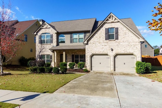 view of front facade with brick siding, a front yard, fence, a garage, and driveway