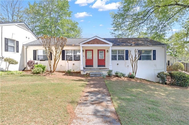 view of front of home with stucco siding and a front lawn