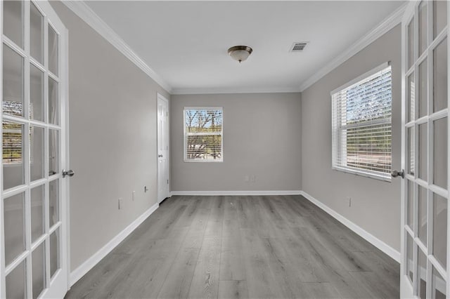 empty room featuring french doors, wood finished floors, baseboards, and ornamental molding