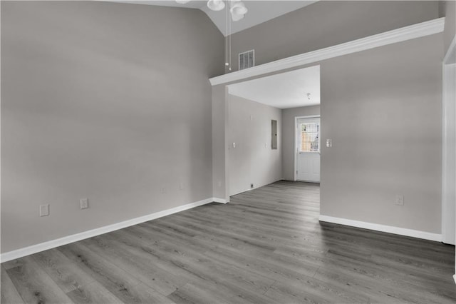 spare room featuring baseboards, a ceiling fan, visible vents, lofted ceiling, and wood finished floors