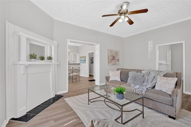 living room with baseboards, a textured ceiling, and wood finished floors