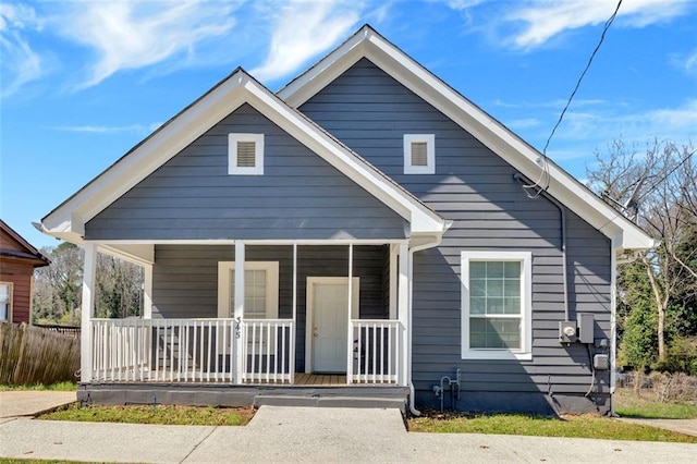 bungalow featuring a porch and fence