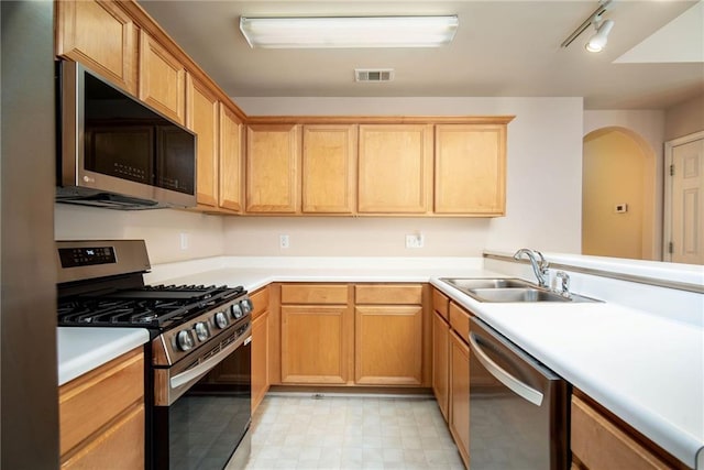 kitchen with appliances with stainless steel finishes, track lighting, and sink