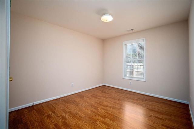 spare room with wood-type flooring